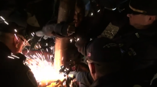 Sparks fly as NYPD officers cut a metal chain